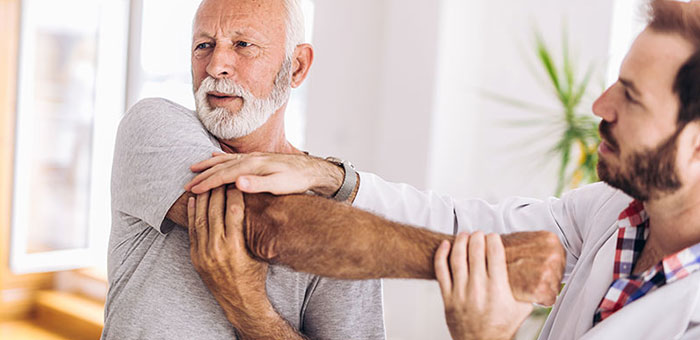 Elderly man receiving shoulder adjustment from Sandpoint chiropractor