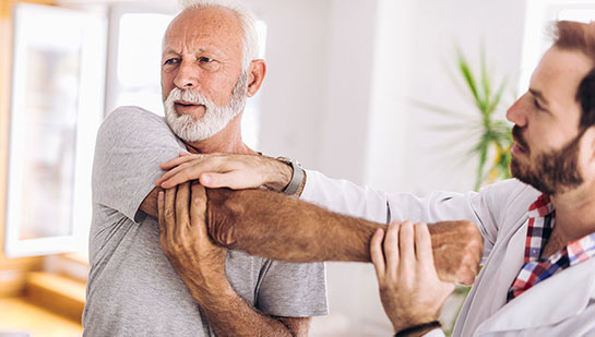 Elderly man receiving shoulder adjustment from Sandpoint chiropractor